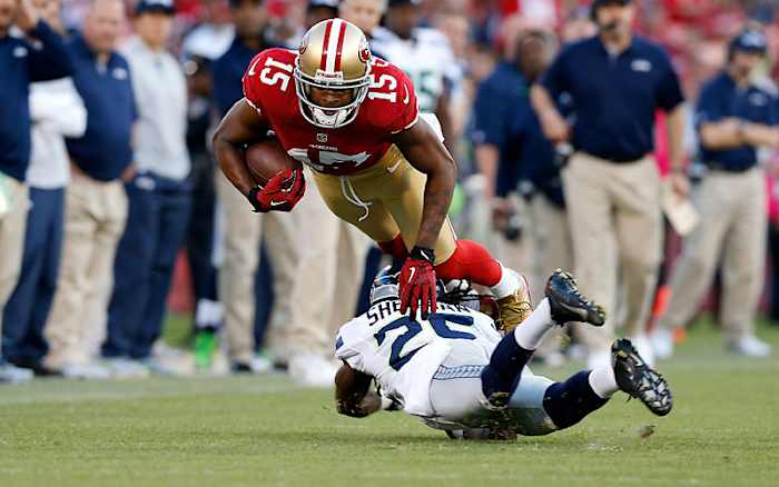 Going low makes the tackler vulnerable to a head shot from the ball-carrier’s churning knees. (Ric Tapia/Icon SMI)